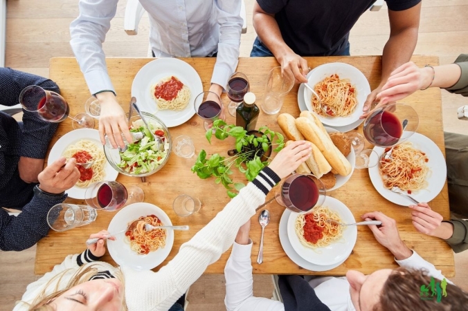 Gemeinsame Mahlzeit, gedeckter Tisch, Personen, die gemeinsam am Tisch sitzen
