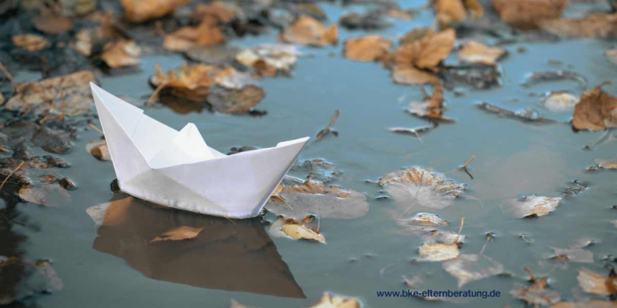 Ein Papierboot in einer Pfütze
